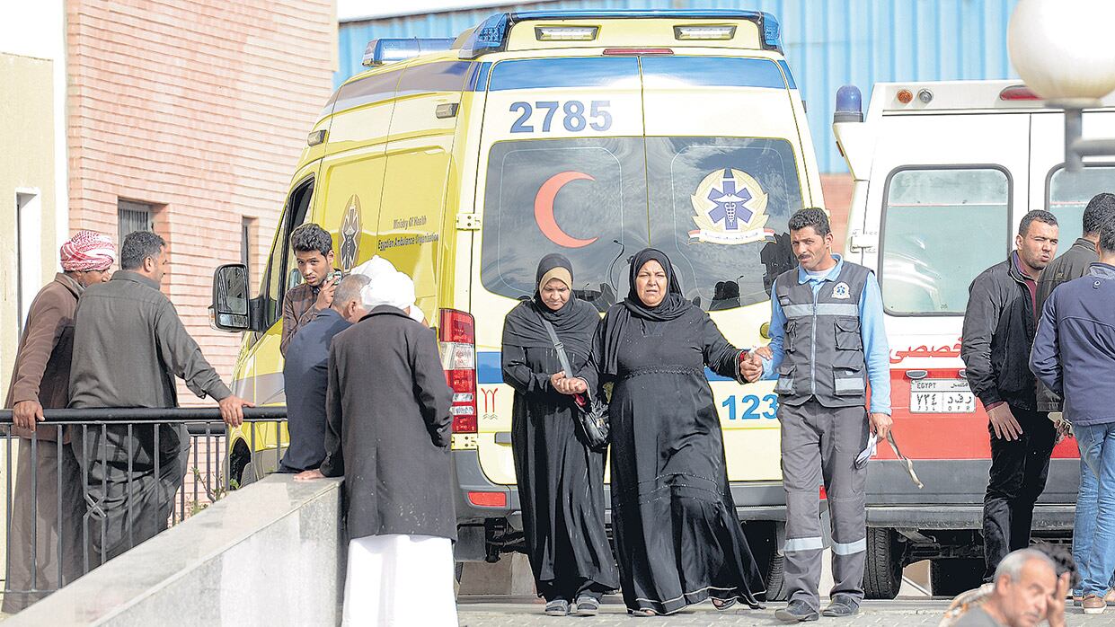 Familiares de las víctimas caminan delante de una ambulancia cerca del templo donde ocurrió el atentado.