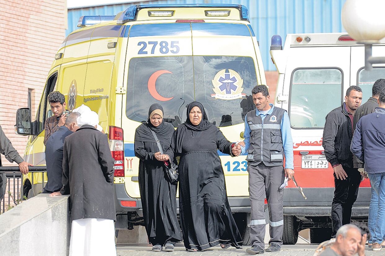 Familiares de las víctimas caminan delante de una ambulancia cerca del templo donde ocurrió el atentado.