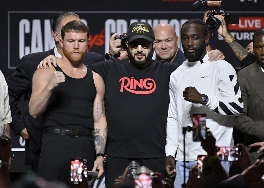 Canelo y Crawford, abrazados por el ministro saudita Turki Alalshikh, uno de los promotores de la pelea. El otro, al fondo, Dana White, presidente de la UFC.