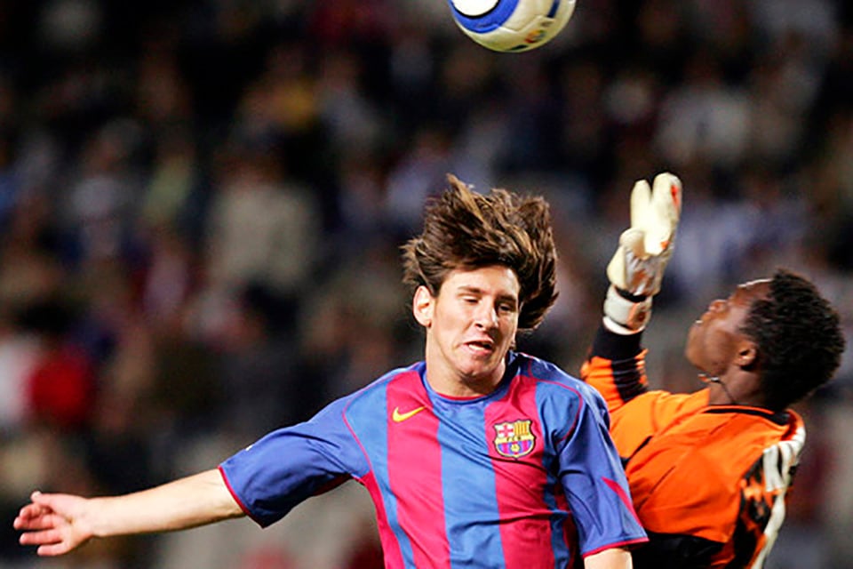 Messi salta a cabecear ante la salida de Kameni.