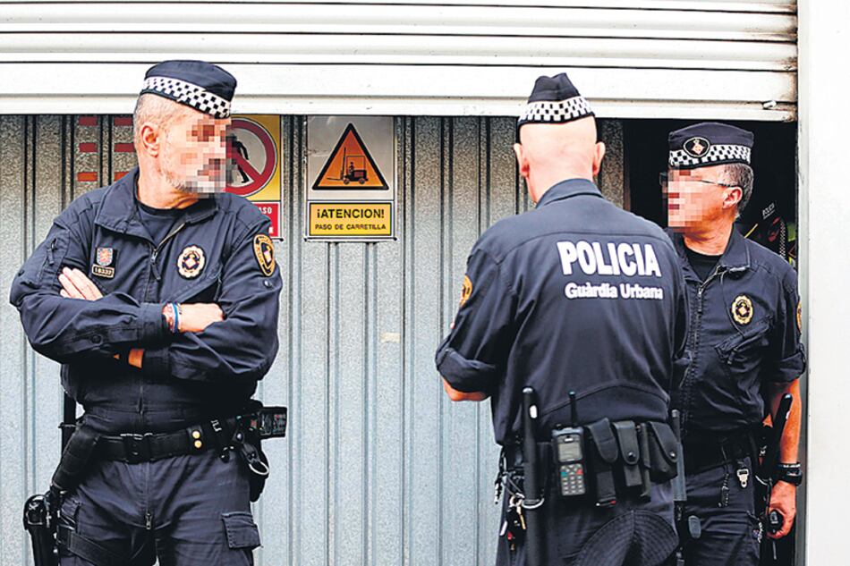 Agentes de la Guardia urbana de Barcelona custodian un almacén municipal desde se guardan urnas.