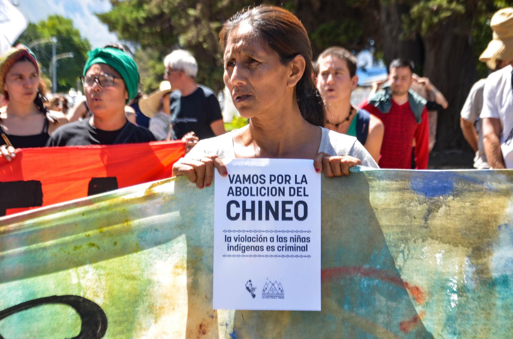 "La violación a las niñas indígenas es criminal", dice el cartel que sostiene una mujer indígena.