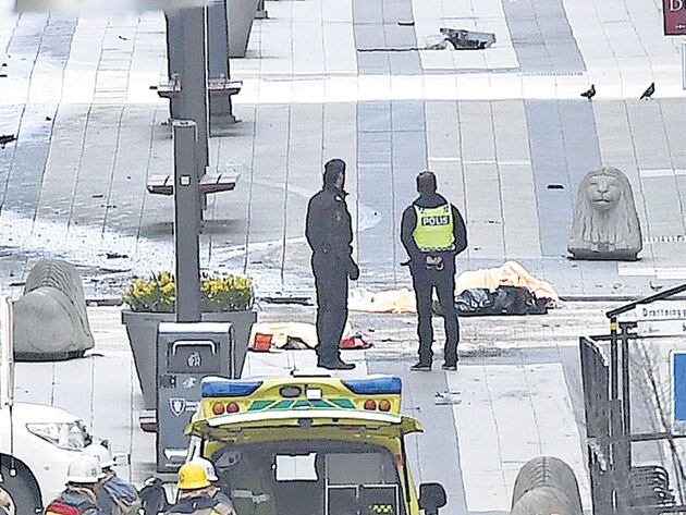 La policía custodia el cuerpo de una de las víctimas.