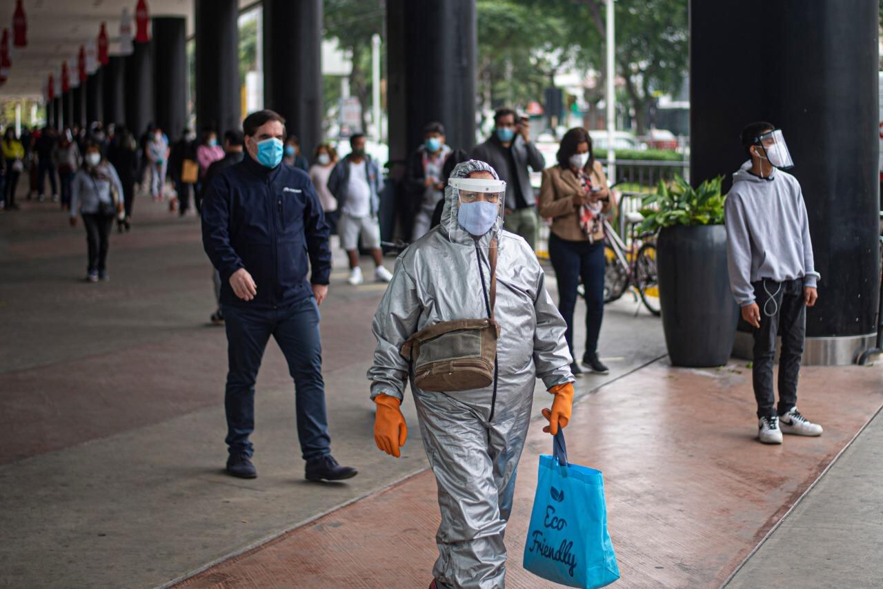 A horas de levantarse la cuarentena residentes de Lima caminan cerca de un shopping.