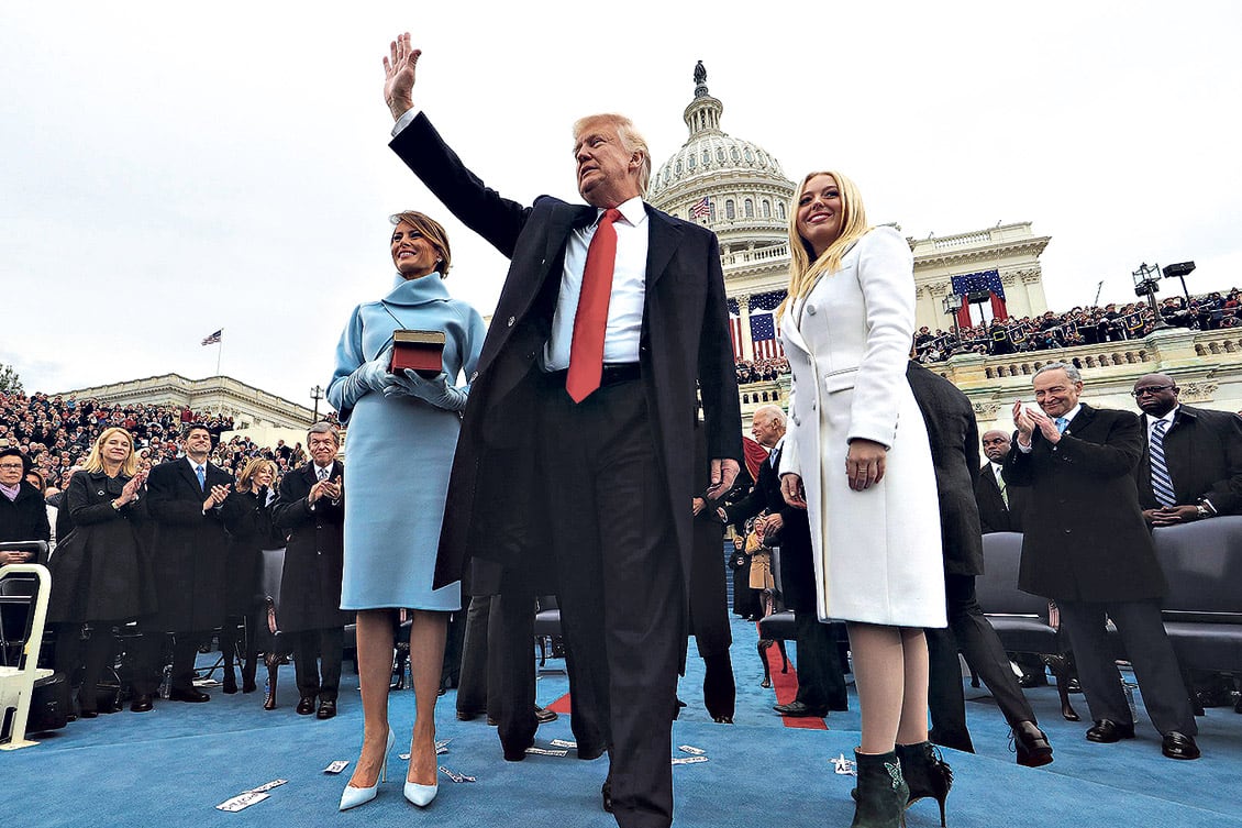 Trump saluda después de jurar como presidente en la puerta del Capitolio junto a su esposa Melania (izq.) y su hija Tiffany.