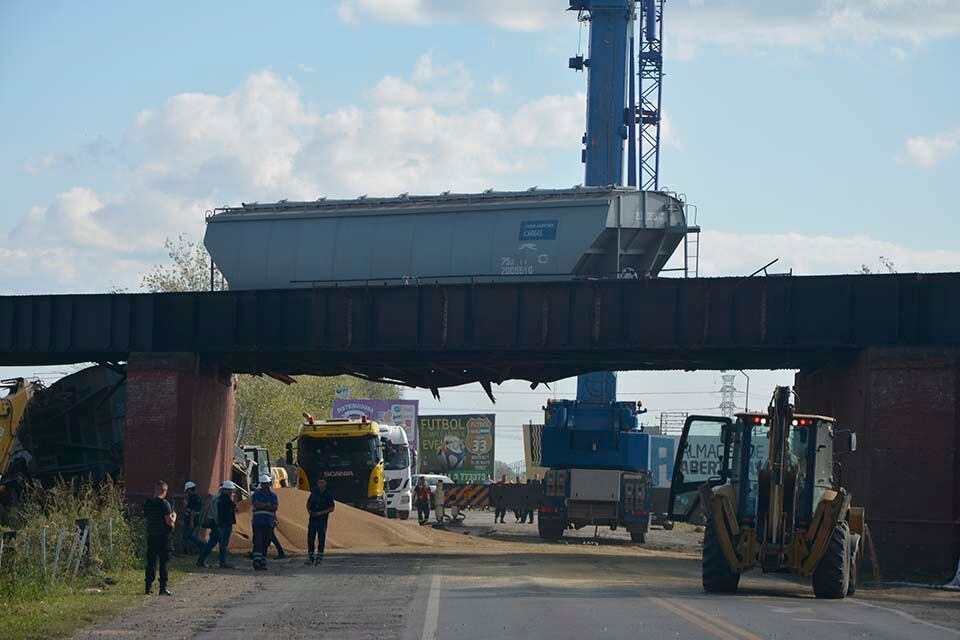 Una grúa maniobra ayer a media tarde para remover el último vagón sobre el puente.