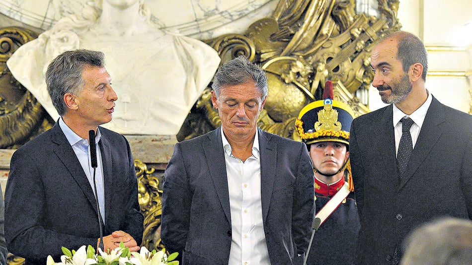 Mauricio Macri cuando le tomó juramento al actual titular de Defensa de la Competencia, Esteban Greco (derecha).