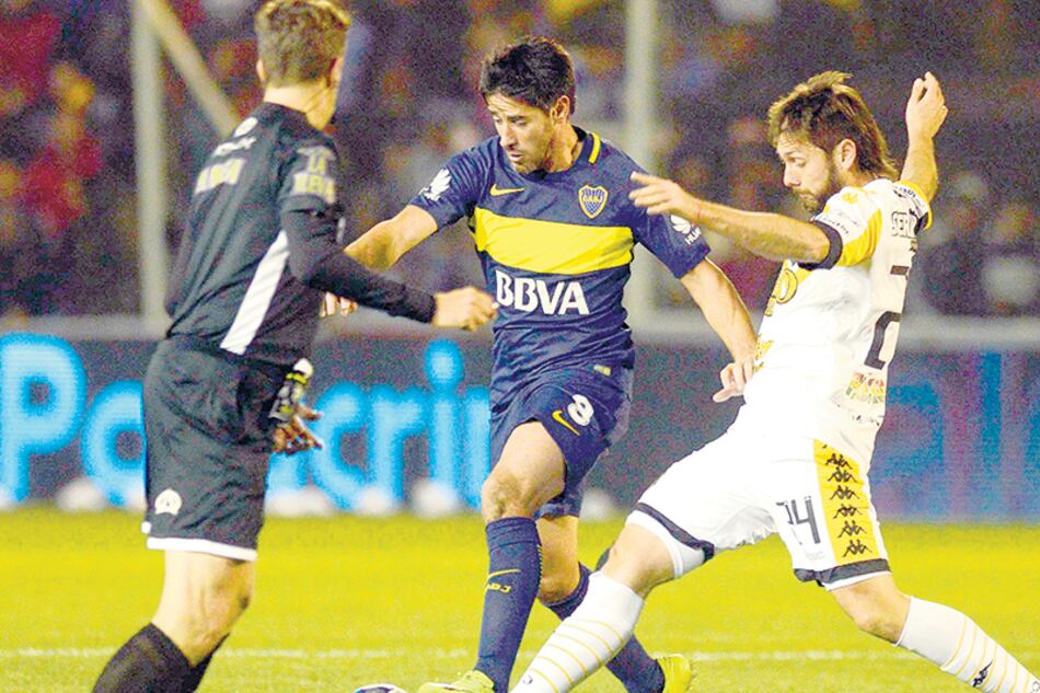 Pablo Pérez lucha por la pelota frente a Parnisari.