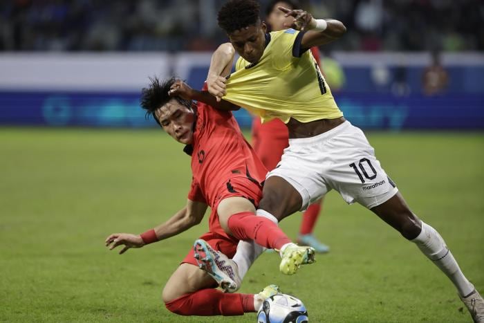 El delantero de Ecuador Nilson Angulo disputa el balón con el coreano Hyunbin Park.