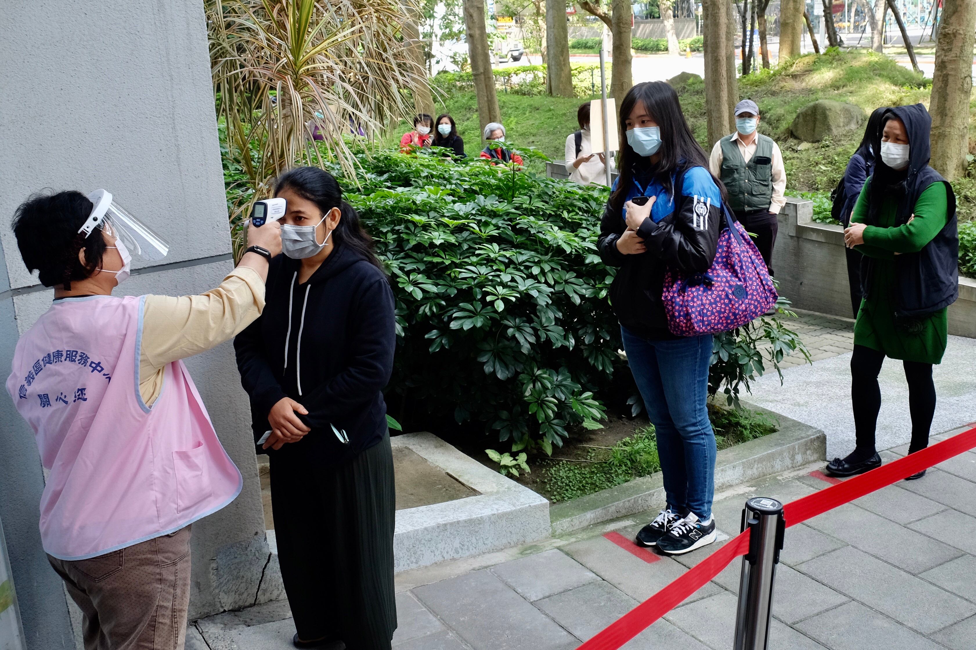 Miden fiebre en una fila para comprar barbijos en Taipei, Taiwan.