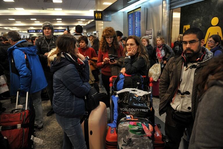 Pasajeros esperan que se normalice la actividad en Ezeiza y Aeroparque.