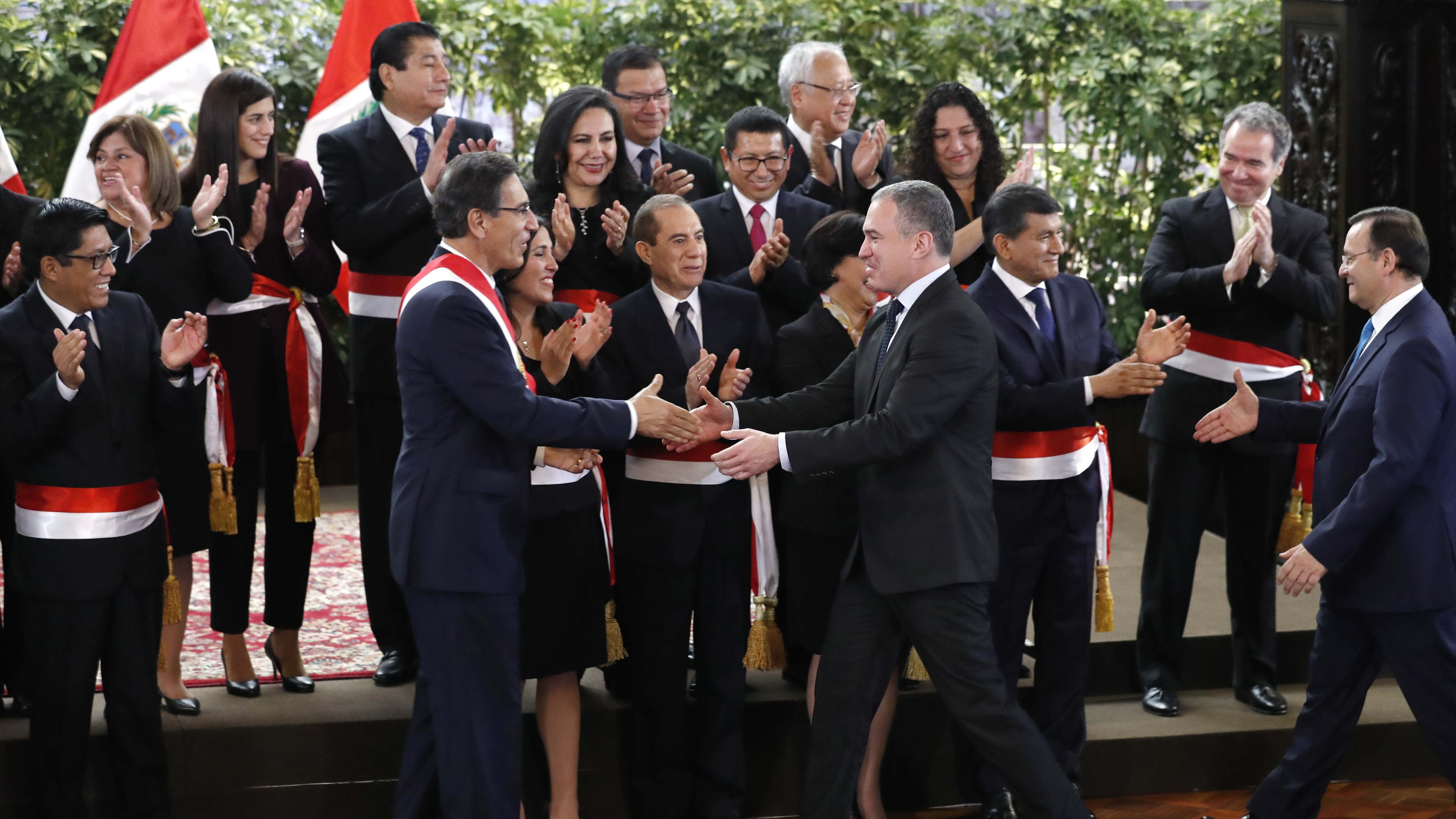 Vizcarra, con banda presidencial, saluda a sus nuevos ministros.
