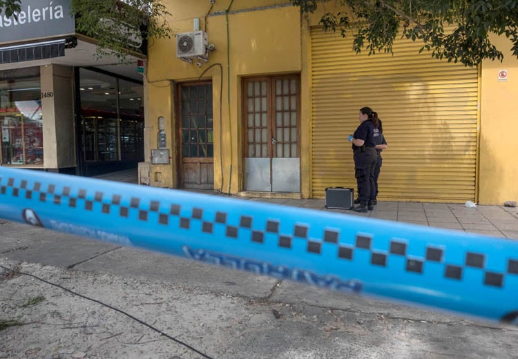 La Policía científica busca rastros frente a la financiera asaltada.