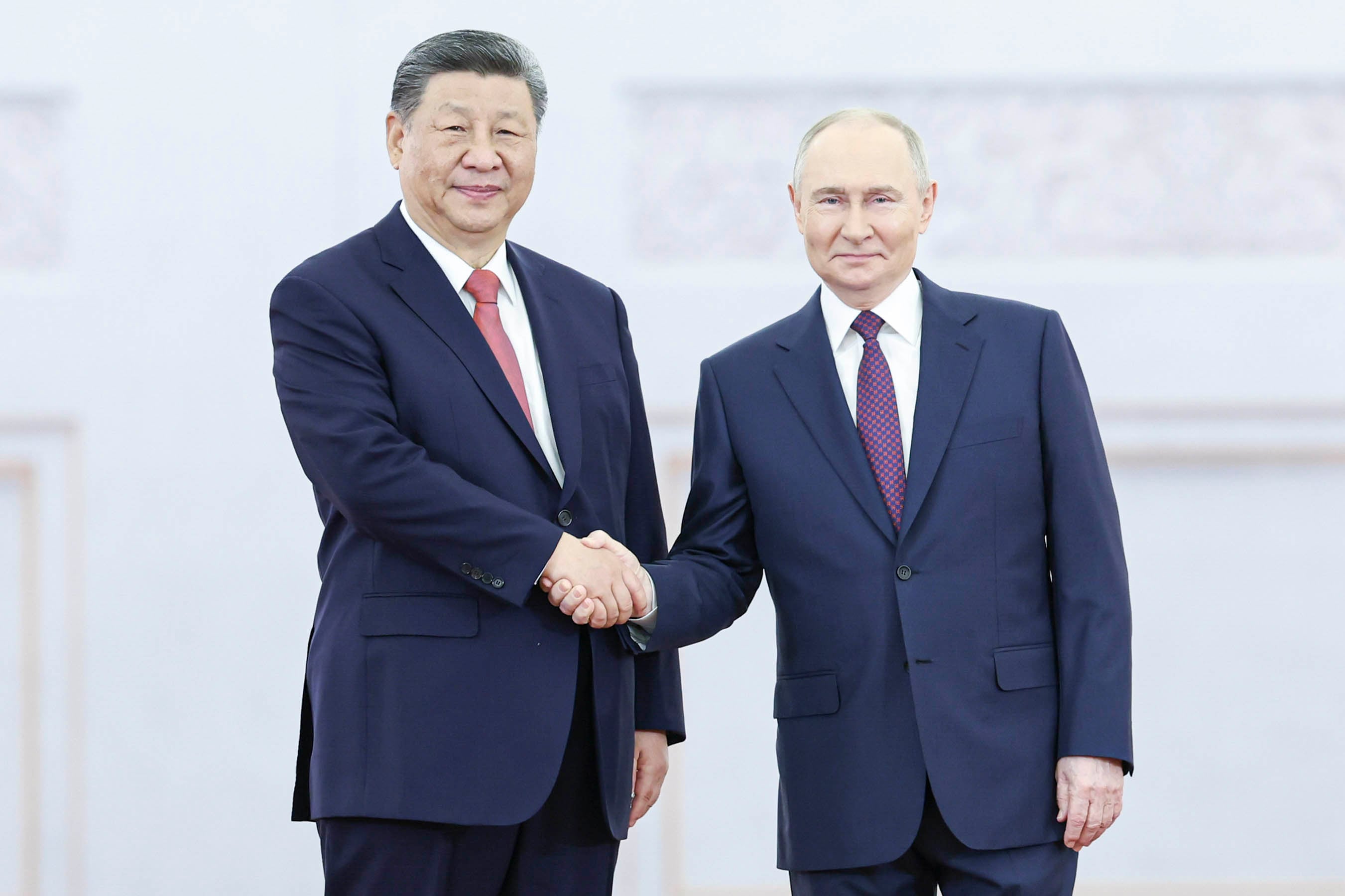 El presidente chino, Xi Jinping, estrecha la mano del presidente ruso, Vladimir Putin, en el Kremlin