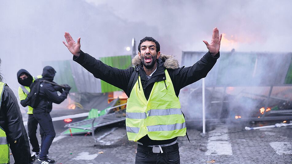 Un chaleco amarillo reacciona durante un corte de la avenida Campos Elíseos.
