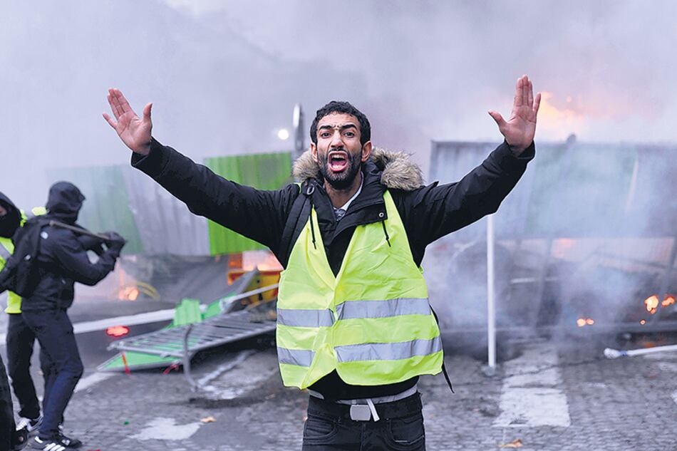 Un chaleco amarillo reacciona durante un corte de la avenida Campos Elíseos.