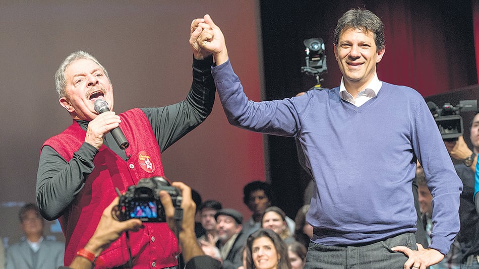 Lula alzando el brazo de Haddad durante un acto en San Pablo, poco antes de que el líder del PT fuera arrestado.