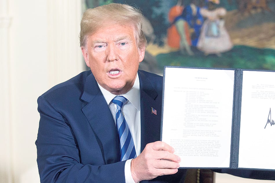 En la Casa Blanca Trump sostiene un memorando presidencial con su firma reestableciendo las sanciones a Irán.