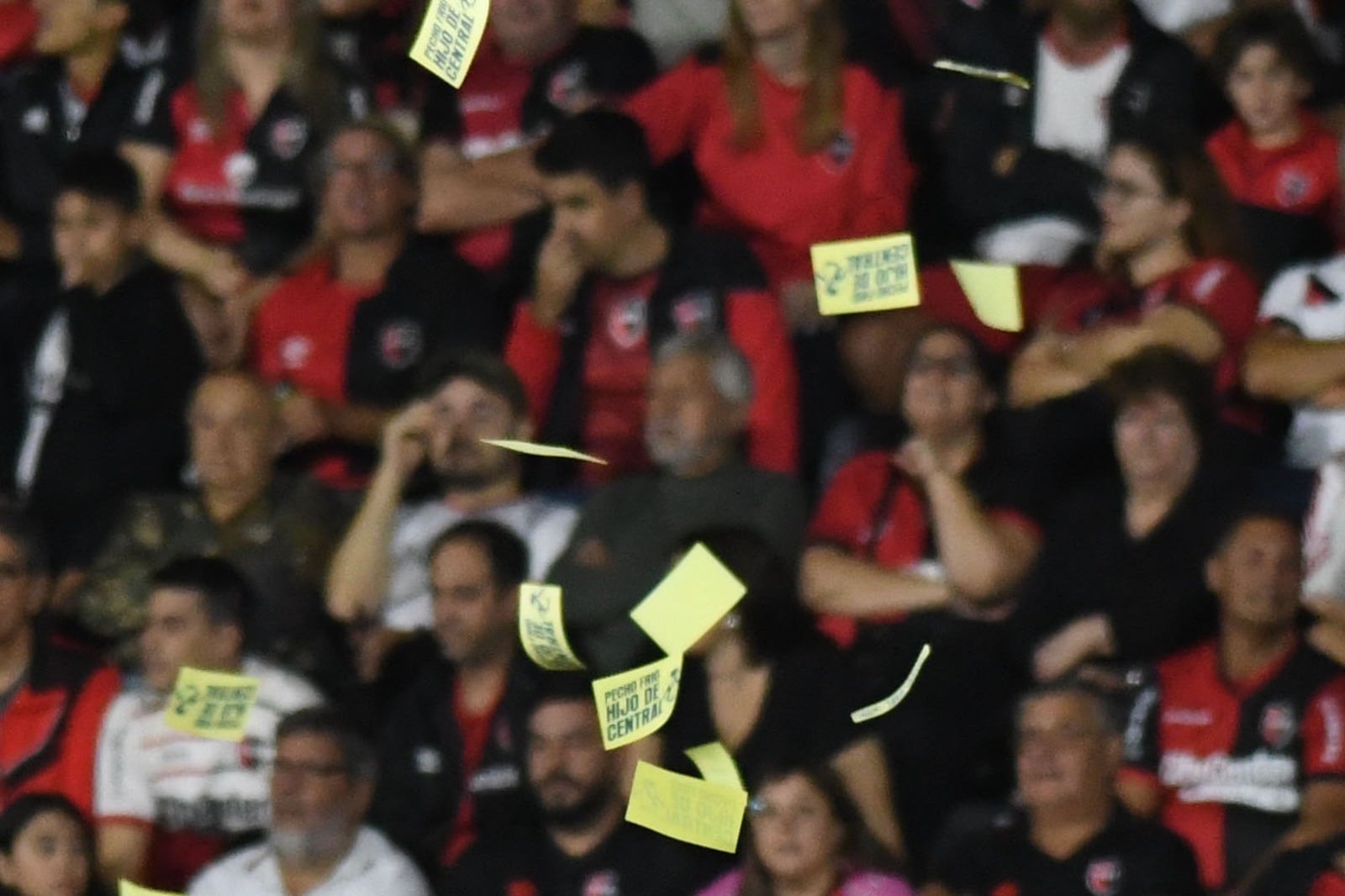 Algunos de los panfletos burlones. Fuera de foco, los hinchas de Newell's