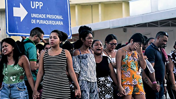 Familiares de los presos rezan afuera de una de las cuatro cárceles de Manaus, en el estado de Amazonas.