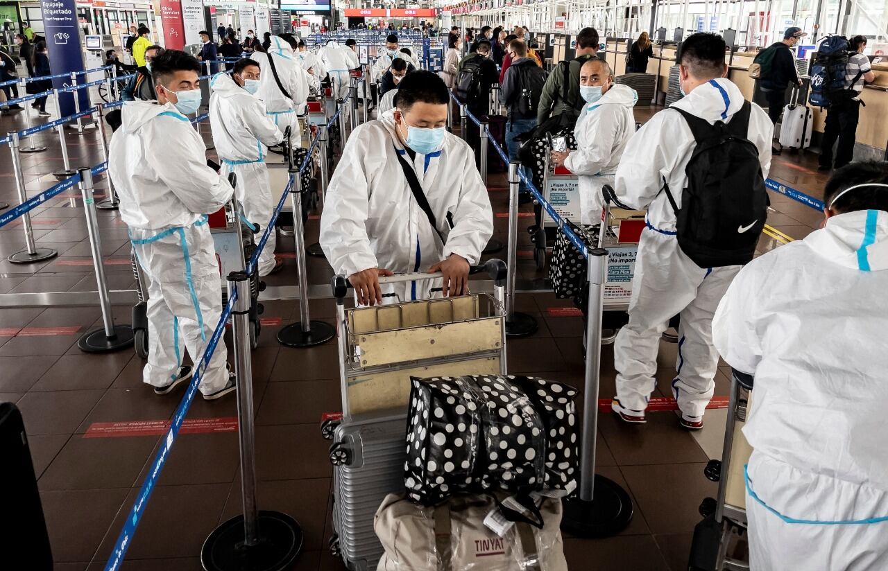 Pasajeros en el aeropuerto de Santiago con ropa de protección.