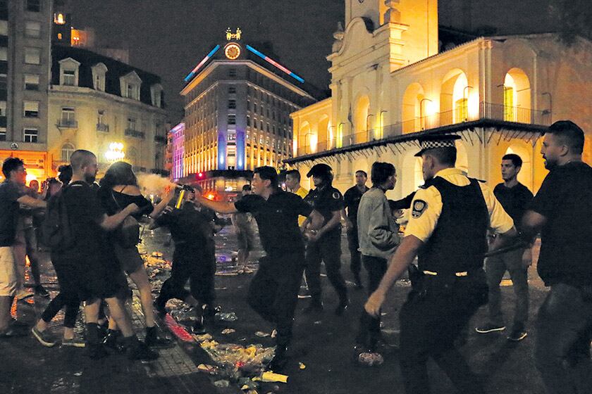 Un policía arroja gas pimienta en el rostro de una manifestante en los episodios frente a la Catedral.