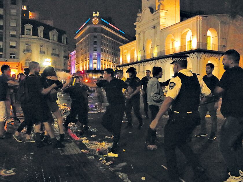 Un policía arroja gas pimienta en el rostro de una manifestante en los episodios frente a la Catedral.