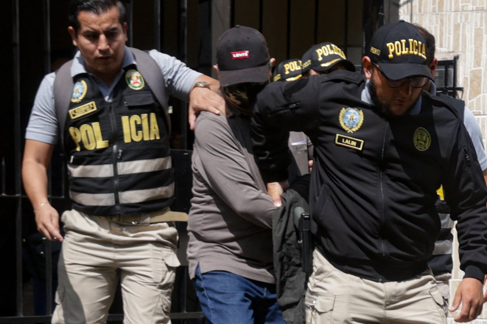 Policías llevan detenido a Nicanor Boluarte después de allanar su casa.