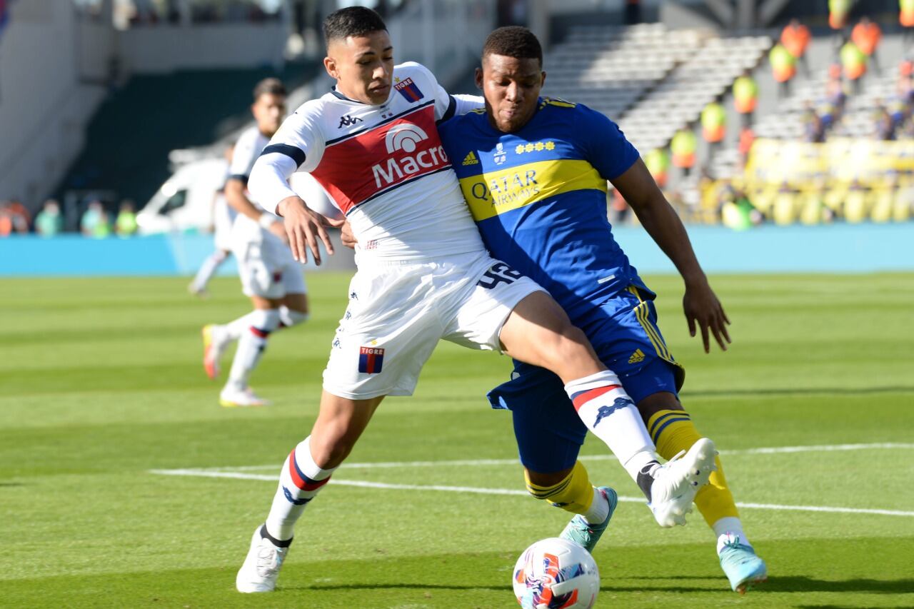 Equi Fernández, en Tigre, aguanta la pelota ante la presión de Fabra.