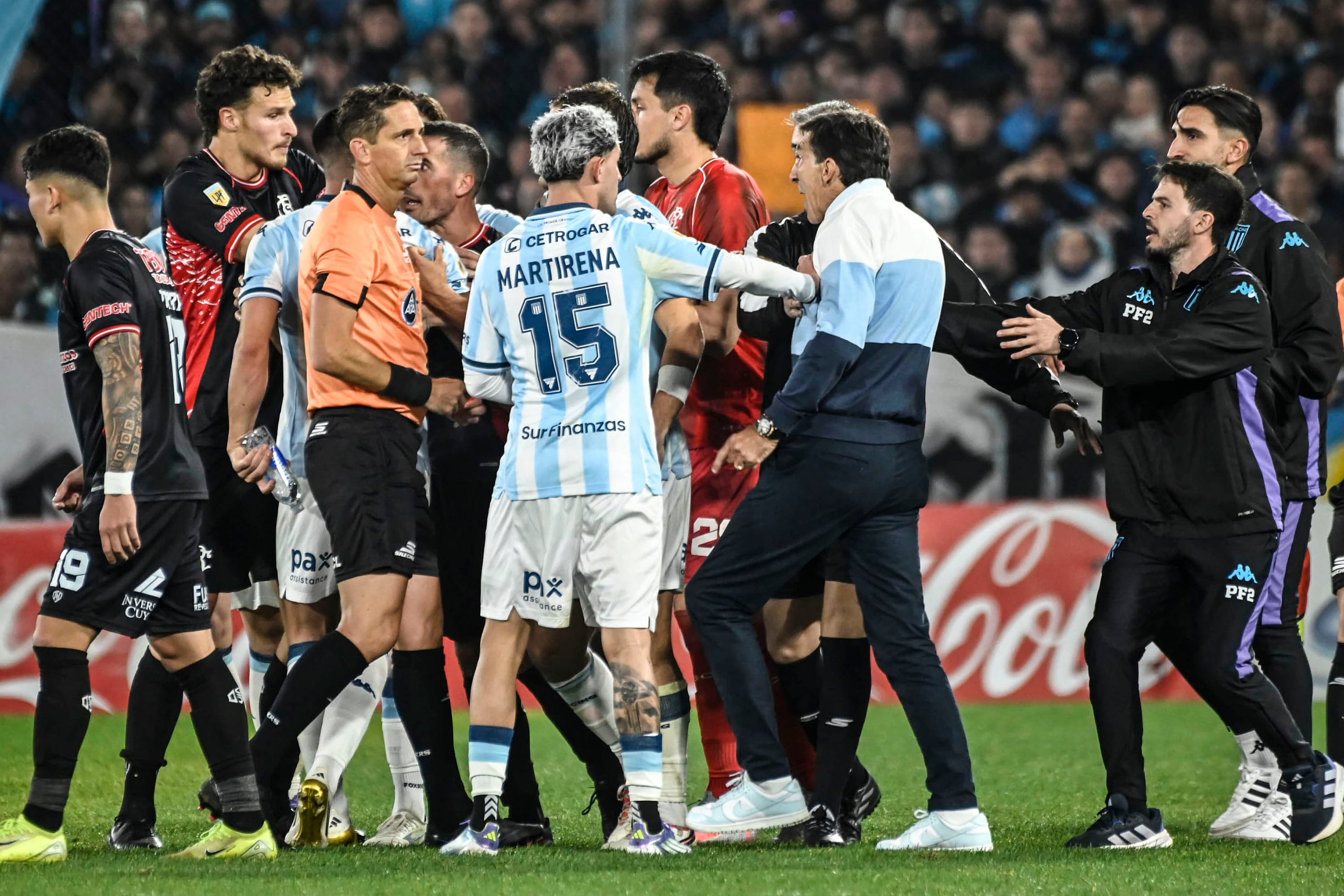 Costas y Racing se van contra Lamolina, quien mete cara de póquer como para enardecer un poco más la furia del DT.