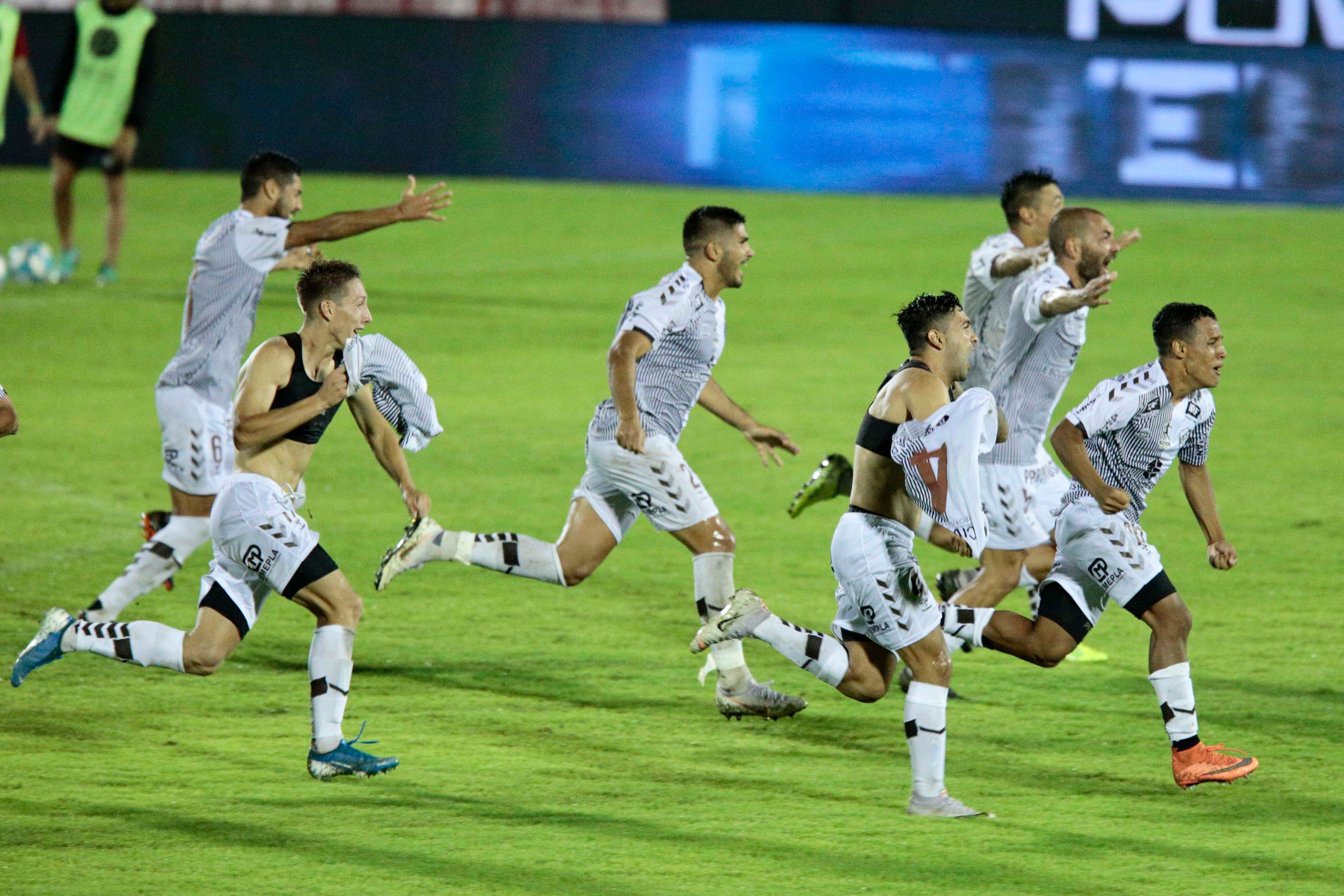 Los jugadores de Platense van en busca de De Olivera.