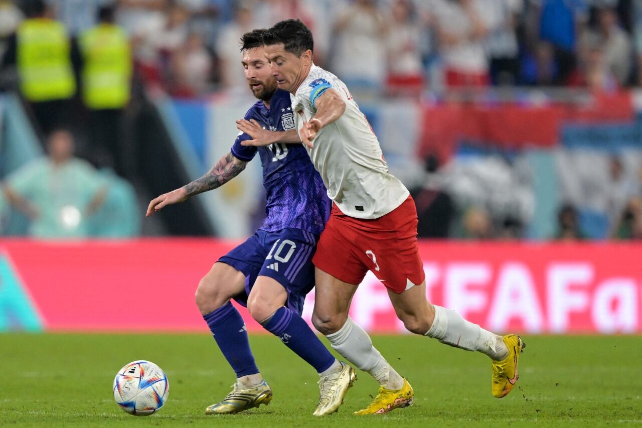 Linoel Messi y Robert Lewandowski, luchan por el control de la pelota.