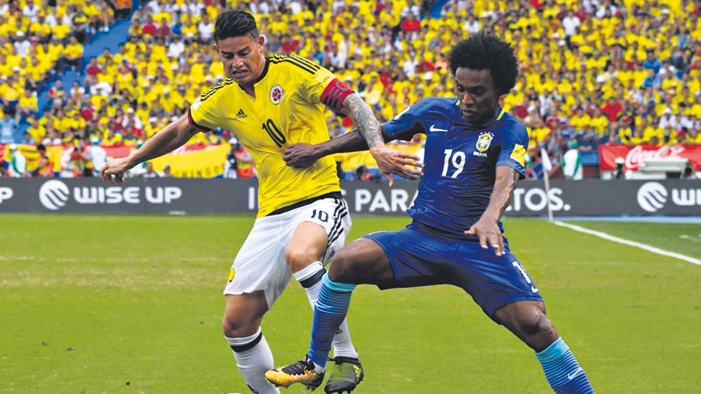El colombiano James Rodríguez lucha por la pelota con el brasileño William.