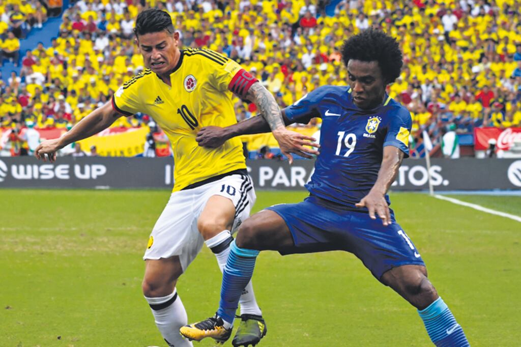 El colombiano James Rodríguez lucha por la pelota con el brasileño William.
