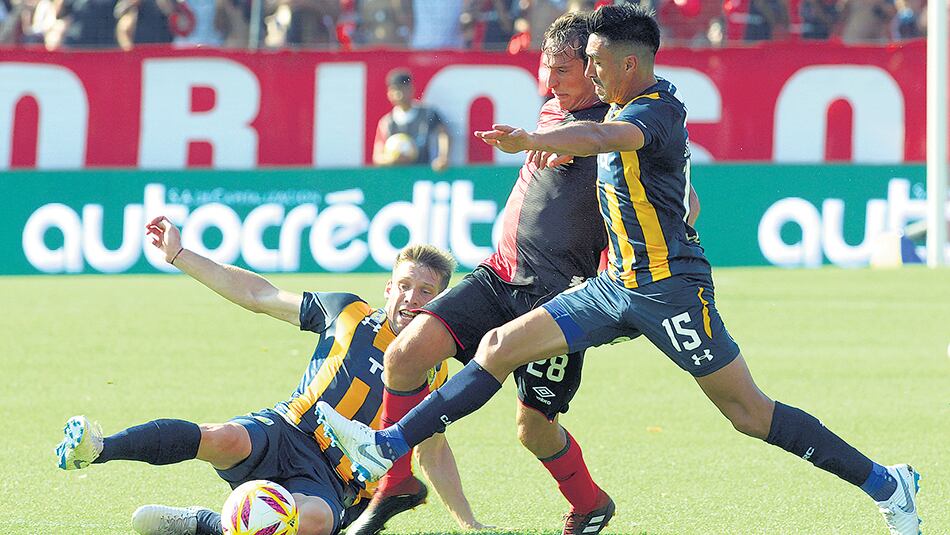 Bittolo intenta pasar entre dos jugadores de Central.