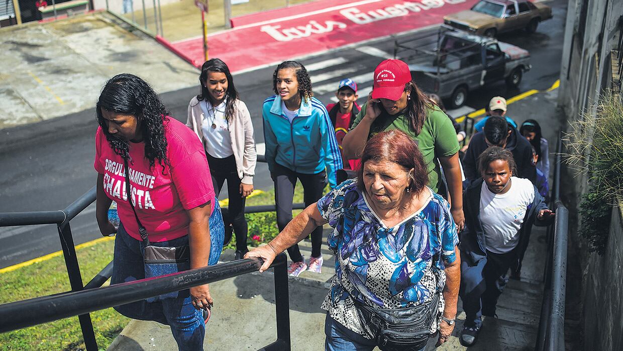 Mujeres venezolanas se dirigen a un centro de votación para elegir constituyentes en el emblemático barrio popular 23 de Enero de Caracas