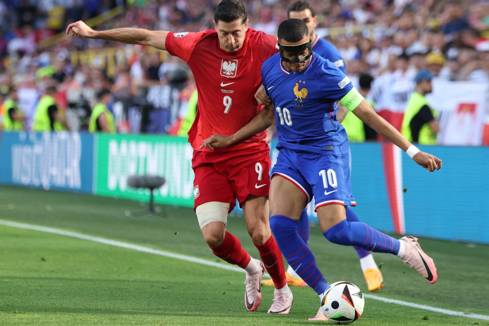 Mbappé, enmascarado, siente la presión de Lewandowski.