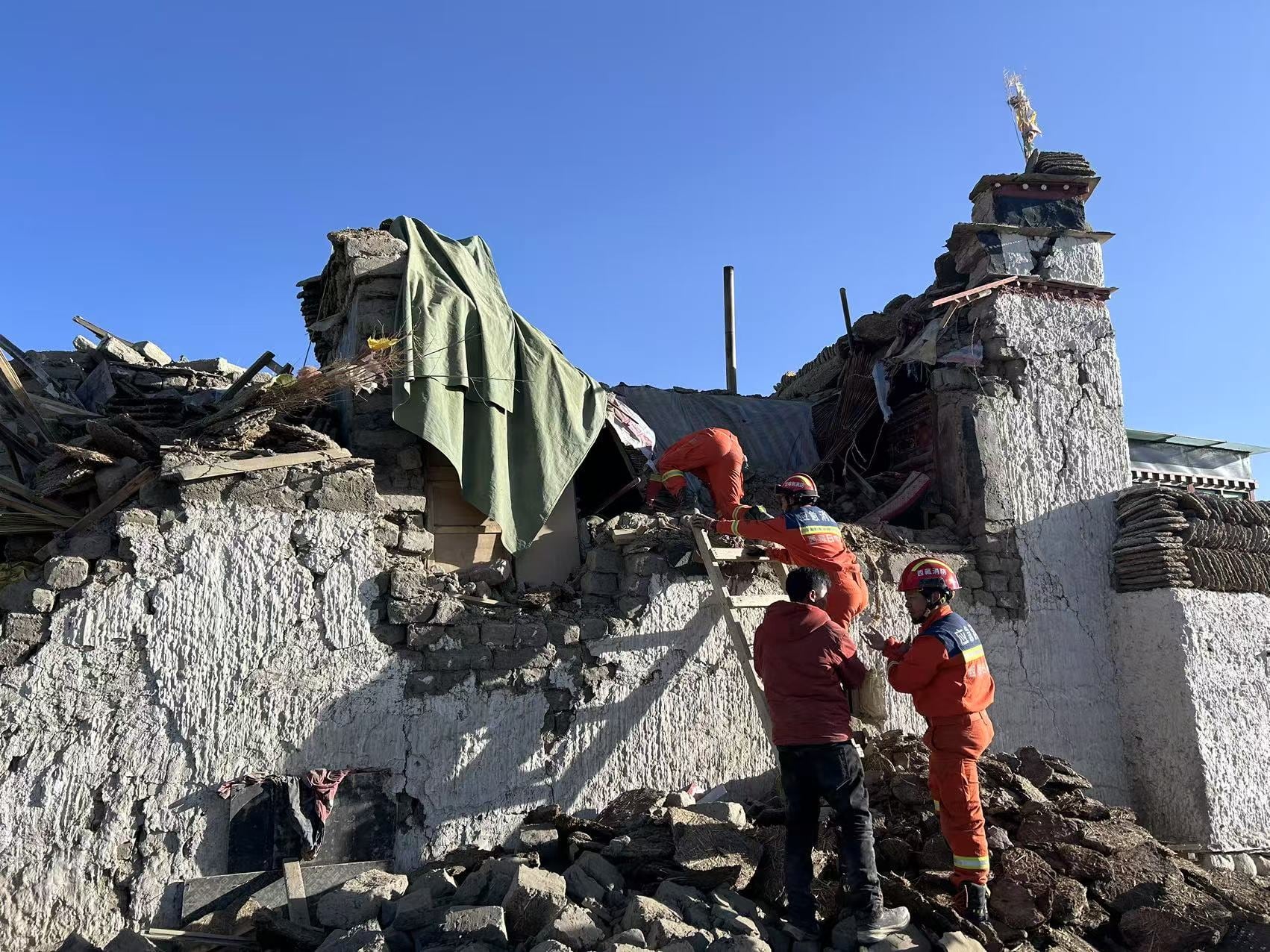 Miembros de equipos de rescate trabajan en una zona afectada por el terremoto en el Tíbet