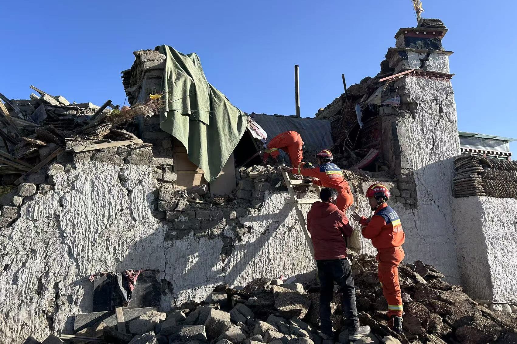 Miembros de equipos de rescate trabajan en una zona afectada por el terremoto en el Tíbet