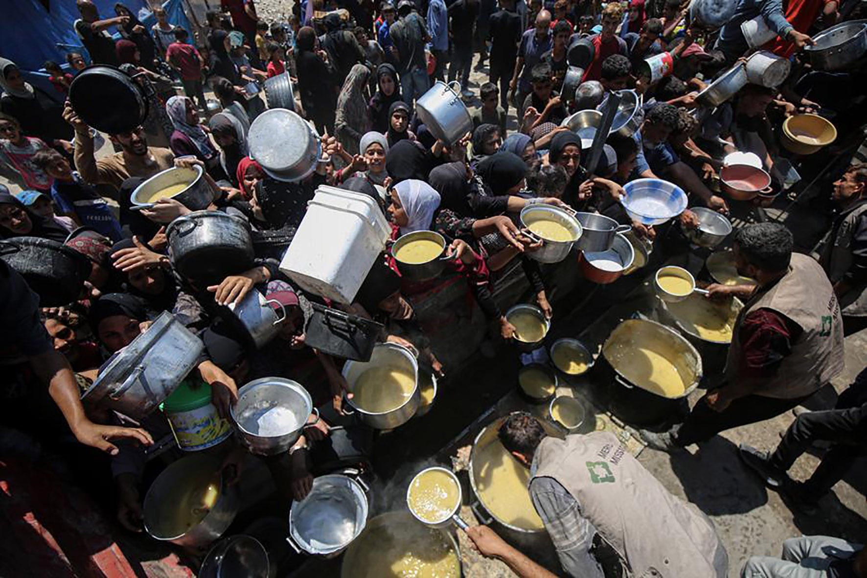 Palestinos desplazados reciben alimentos en Ciudad de Gaza. 