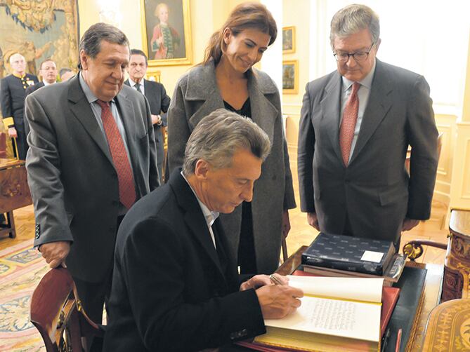 Mauricio Macri junto a Juliana Awada y Ramón Puerta al firmar el libro de huéspedes del Palacio de El Pardo.