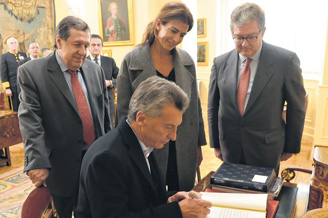 Mauricio Macri junto a Juliana Awada y Ramón Puerta al firmar el libro de huéspedes del Palacio de El Pardo.