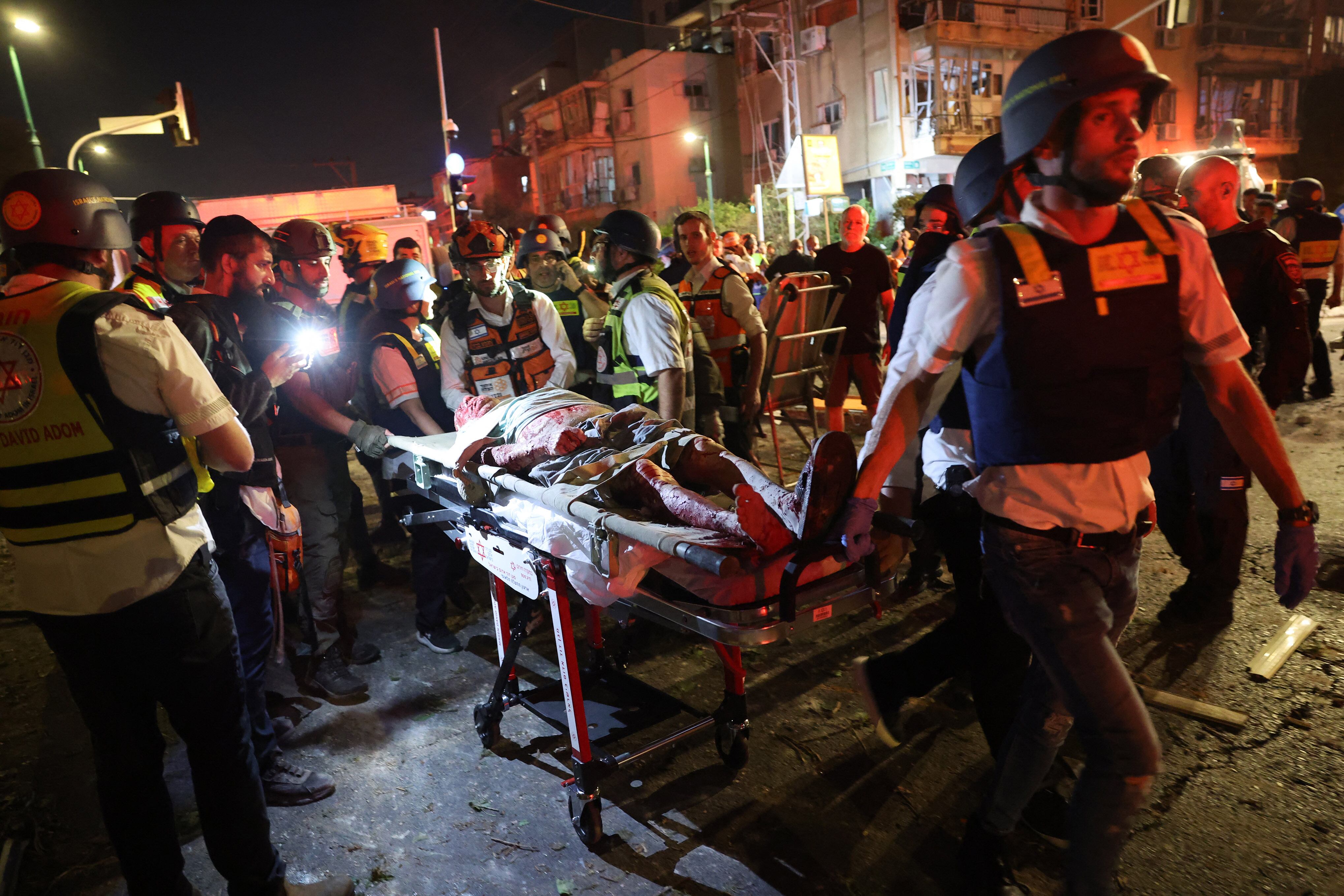 Socorristas israelíes evacúan a un hombre alcanzado por un misil disparado desde Irán, en Ramat Gan, cerca de Tel Aviv