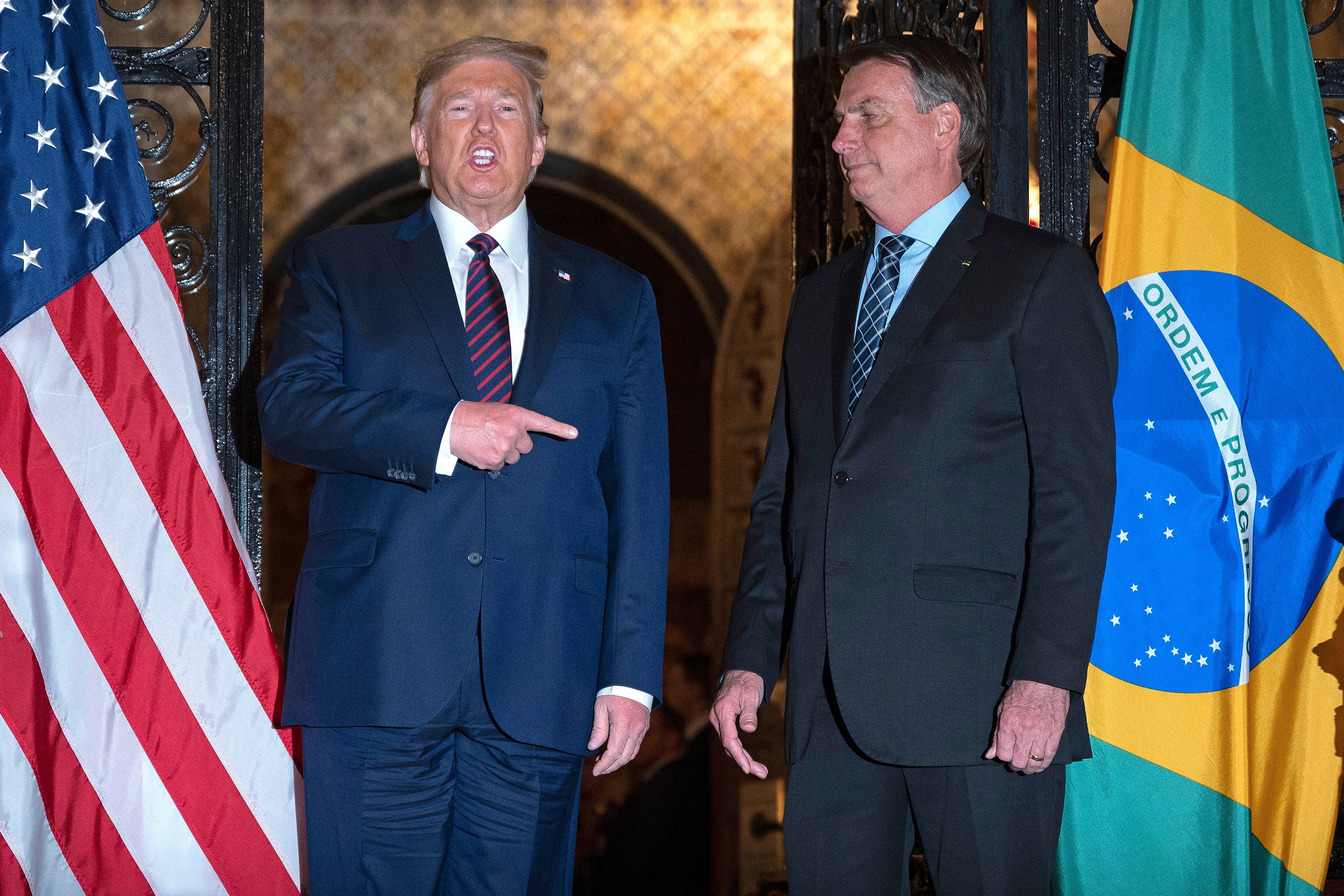 Trump señala a Bolsonaro durante una cena la casa del estadounidense en Palm Beach.