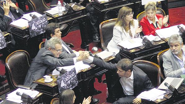 Agustín Rossi saluda a Axel Kicillof después de su intervención durante la sesión especial.