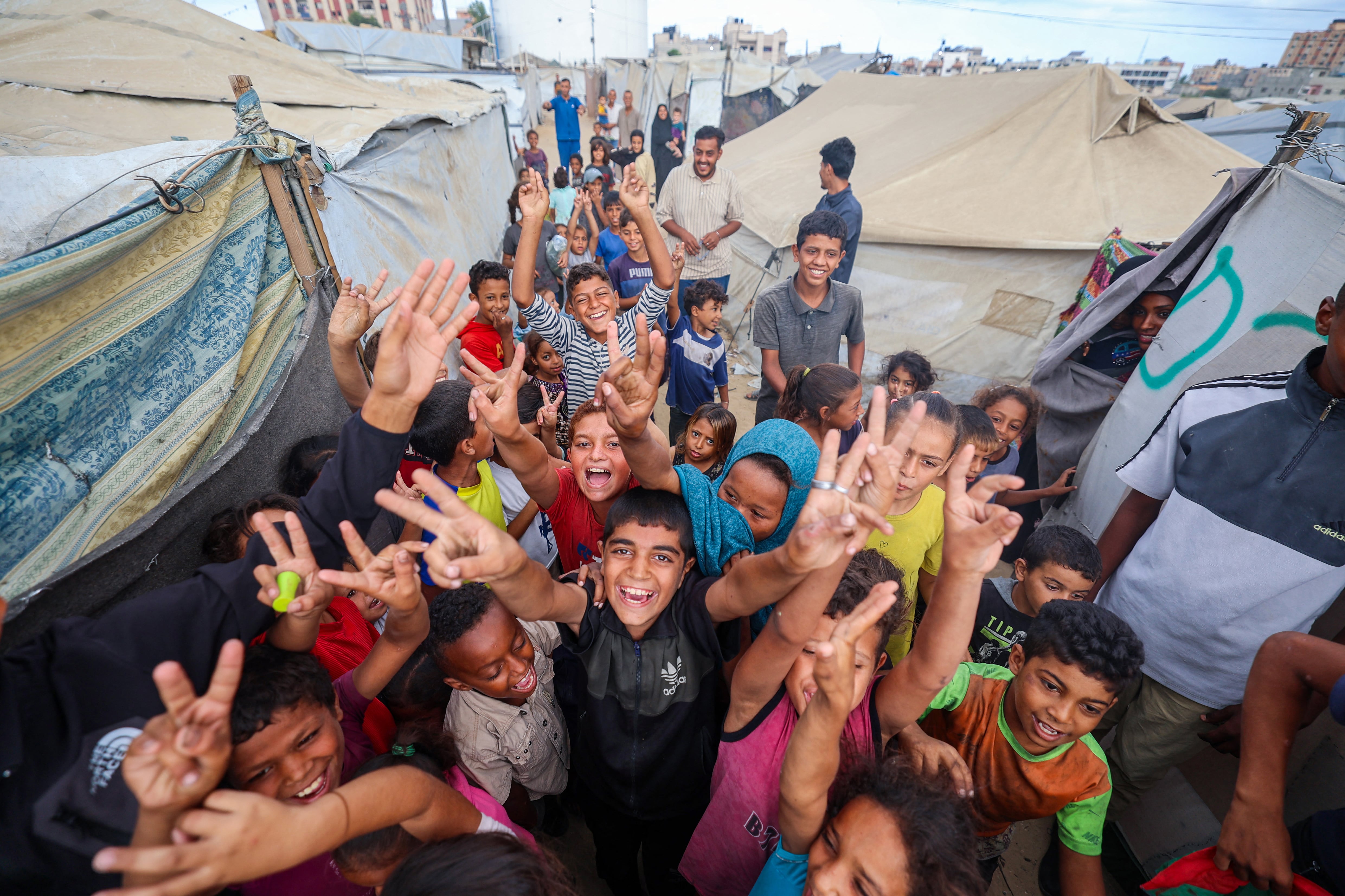 Niños palestinos celebran la tregua en un campamento para desplazados en Nuseirat, en el centro de Gaza