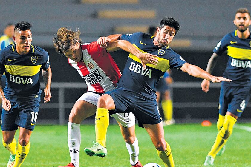 Centurión y Peruzzi observan la lucha por la pelota que protagonizan Pablo Pérez y Cejas.