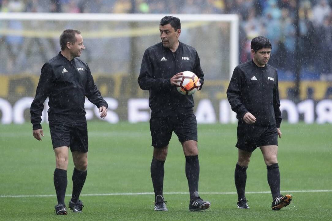 Tobar (con la pelota) y su terna en la Bombonera, el día de la suspensión por lluvia de la final de ida de 2018.