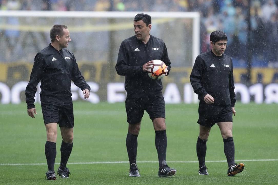 Tobar (con la pelota) y su terna en la Bombonera, el día de la suspensión por lluvia de la final de ida de 2018.