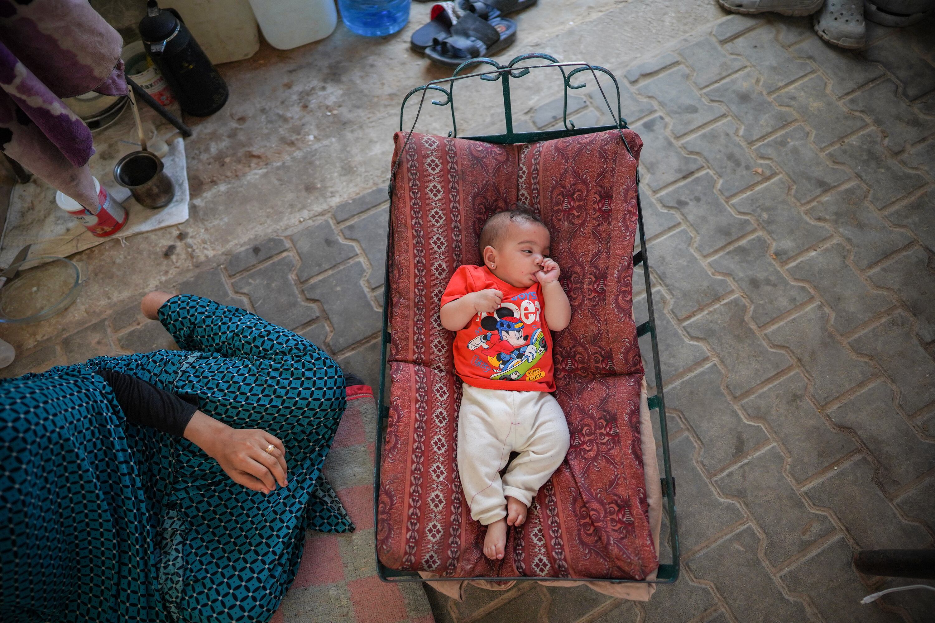 Una madre palestina ysu bebé en un cmpamento para desplazados en el centro de la Franja de Gaza.